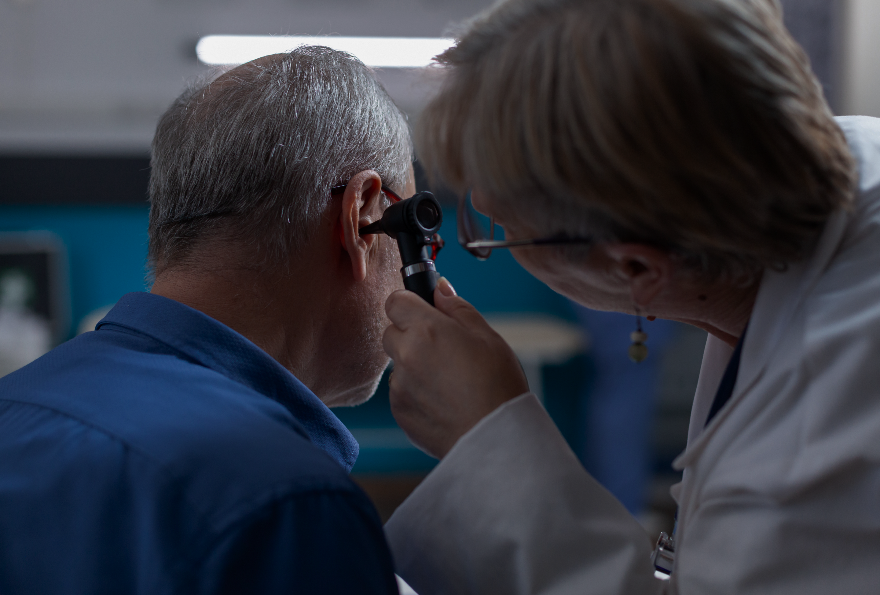 imagem de uma médica examinando o ouvido de uma paciente